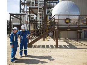 Oil plant workers chat outside a processing facility 120 kilometres  outside south of Fort McMurray, Alta.