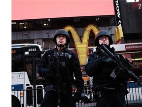 New York police officers with high powered rifles patrol in Times Square on December 7, 2015 following a series of mass shootings in the U.S. and the terrorist attacks in Paris last month.