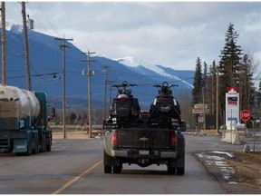 Two men drive a truck with snowmobiles on the back after leaving the RCMP detachment in McBride, B.C., on Saturday January 30, 2016. Five snowmobilers died Friday in a major avalanche in the Renshaw area east of McBride. THE CANADIAN PRESS/Darryl Dyck