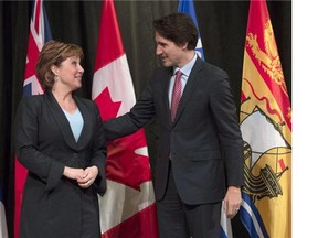 Prime Minister Justin Trudeau speaks with B.C. Premier Christy Clark as he officially welcomes her to the First Ministers meeting at the Museum of Nature, in Ottawa, on November 23, 2015. Clark says the new process for appointing senators on merit will give legitimacy to an unelected, unaccountable upper house in which her province will remain grossly under-represented.