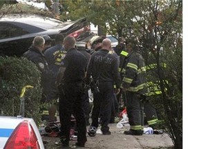 First responders examine an automobile after its driver lost control and plowed into a group of trick-or-treaters in New York, Saturday, Oct. 31, 2015. Three people were killed, including a 10-year-old girl.