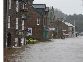 A family and their dog are rescued by the coastguard on Warwick Road in the center of Carlisle after heavy rain from Storm Desmond tore through Britain.