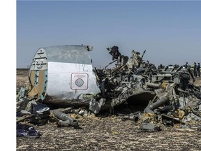 In this photo provided by Russian Emergency Situations Ministry, Egyptian Military on cars approach a plane's tail at the wreckage of a passenger jet bound for St. Petersburg in Russia that crashed in Hassana, Egypt,.