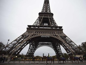 Mounted police patrol in Paris on November 14, 2015, at the Eiffel Tower, which has been closed to the public following a series of coordinated attacks in and around Paris late November 13, which left at least 128 people dead. Schools, markets, museums and major tourist sites in the Paris area were closed and sporting fixtures were cancelled following the terror attacks on the French capital, local authorities said.