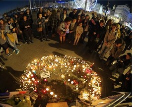 People gather on November 15, 2015 at a makeshift memorial in the "Vieux port" of Marseille, for the victims of November 13 attacks in Paris.