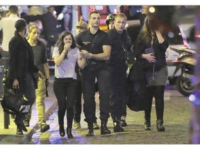 People are evacuated following an attack at Le Bataclan, a concert hall, Friday in Paris. Scores of people were killed in multiple attacks.