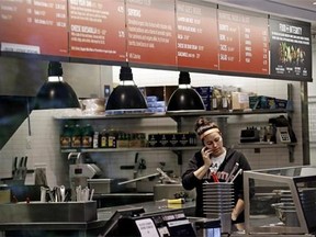 A woman talks on the phone as she stands in the kitchen area of a closed Chipotle restaurant, Monday, Nov. 2, 2015, in Seattle. An E. coli outbreak linked to Chipotle restaurants in Washington state and Oregon has sickened nearly two dozen people in the third outbreak of foodborne illness at the popular chain this year. Cases of the bacterial illness were traced to six of the fast-casual Mexican food restaurants, but the company voluntarily closed down 43 of its locations in the two states as a precaution.