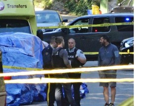 A parked vehicle is covered haphazardly by a blue tarp as North Vancouver RCMP detectives investigated a homicide earlier this year.