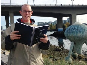 Paul Kingsbury holds a copy of a UFO field investigator’s manual published by Mufon, the Mutual UFO Network based in the U.S. He’s standing on the seawall in False Creek by Jerry Pethick’s sculpture Time Top near the Cambie Bridge