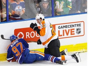Philadelphia Flyers defenceman Brandon Manning looks over an injured Edmonton Oilers centre Connor McDavid after they crashed into the end boards during Tuesday night’s NHL game at Rexall Place in Edmonton.