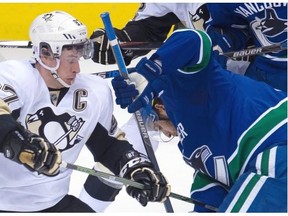 Pittsburgh Penguins’ center Sidney Crosby (87), left, vies for control of the puck with Vancouver Canucks’ center Brandon Sutter (21) during first period NHL action, in Vancouver, on Wednesday, Nov. 4, 2015.