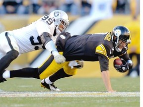 Pittsburgh Steelers quarterback Ben Roethlisberger injuries his left foot as he’s being tackled by Oakland Raiders’ Aldon Smith during NFL action Sunday in Pittsburgh. Roethlisberger wasn’t able to return. The Steelers won 38-35. 
 Associated Press/Don Wright