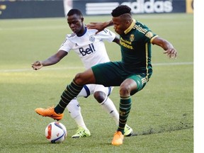 Portland Timbers defender Alvas Powell, right, controls the ball against Vancouver Whitecaps midfielder Kekuta Manneh during the first half of an MLS soccer game in Portland, Ore., Saturday, July 18, 2015.