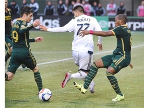 Portland Timbers forward/midfielder Darlington Nagbe, right) takes the ball away from Vancouver Whitecaps midfielder Pedro Morales as Portland Timbers defender Jorge Villafana closes in during the second half of an MLS western conference semifinal soccer match in Portland, Ore., on Sunday. The match ended in a 0-0 draw.