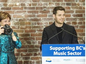 Premier Christy Clark pretends to take pictures of all the famous faces in the audience while Michael Buble is at the podium during Thursday’s music industry event in Vancouver.