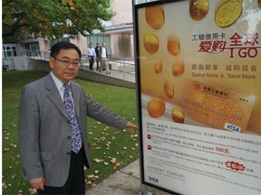 Richmond Coun. Chak Au stands next to a bus shelter ad near City Hall that is printed almost entirely in Chinese.
