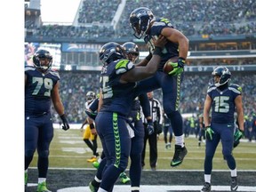 Running back Thomas Rawls #34 of the Seattle Seahawks is congratulated by teammates after scoring a touchdown in the third quarter against the Pittsburgh Steelers at CenturyLink Field on November 29, 2015 in Seattle, Washington.