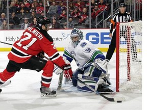Ryan Miller #30 of the Vancouver Canucks makes a save against Kyle Palmieri #21 of the New Jersey Devils during overtime at the Prudential Center on November 8, 2015 in Newark, New Jersey. The Devils defeated the Canucks 4-3 in overtime.