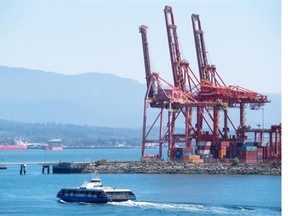 A SeaBus passes cargo cranes at the port while crossing Burrard Inlet to North Vancouver. The head of Port Metro Vancouver says protecting industrial land is an “urgent issue.”