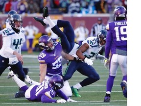 Seattle Seahawks punter Jon Ryan (9) flips over as he run the ball during the first half of an NFL wild-card football game against the Minnesota Vikings, Sunday, Jan. 10, 2016, in Minneapolis.