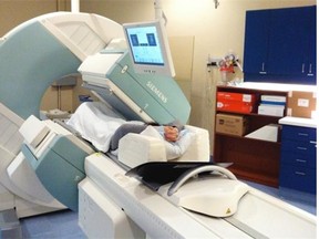 SPECT machine: The patient lies on a table that slides through the machine, while a pair of gamma cameras rotate around her.