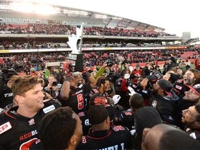 Ottawa Redblacks wide receiver Ernest Jackson (9) holds up the East Division trophy as the Redblacks celebrate their victory over the Hamilton Tiger-Cats in the CFL East Division final in Ottawa, Sunday November 22, 2015. THE CANADIAN PRESS/Sean Kilpatrick