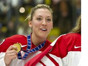 In this April 14, 2012, file photo, Canada's Meghan Agosta shows off her gold medal after Canada defeated the United States at the World Women's Ice Hockey Championships in Burlington, Vt. Agosta has seen some things as a new constable in the Vancouver Police Department. She returns to the Canadian women's hockey team a changed woman. THE CANADIAN PRESS/Paul Chiasson