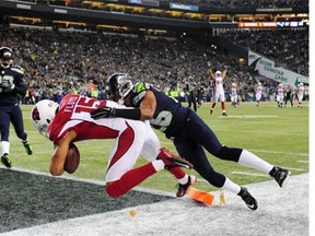 Michael Floyd #15 of the Arizona Cardinals scores a touchdown during the second quarter as Cary Williams #26 of the Seattle Seahawks defends at CenturyLink Field on November 15, 2015 in Seattle, Washington.
