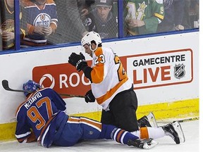 Edmonton centre Connor McDavid (97) is talked to by Philadelphia defenceman Brandon Manning (23) after a hard hit into the boards during the second period of an NHL game between the Edmonton Oilers and the Philadelphia Flyers at Rexall Place in Edmonton on Tuesday, Nov. 3, 2015.