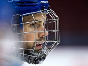 Vancouver Canucks' defenceman Dan Hamhuis, who was injured after being struck in the face by a puck during a game in December, wears a cage on his helmet during NHL hockey practice in Vancouver, B.C., on Monday, January 25, 2016.