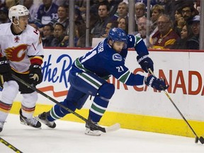 Vancouver Canucks' Brandon Sutter digs for the puck against the Calgary Flames in the first period of a regular season NHL hockey game at Rogers arena Vancouver October 10 2015.