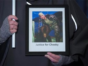 A woman holds a photo of Anaheim Ducks' defenceman Clayton Stoner posing with a grizzly bear as protesters against illegal poaching and hunting gather outside B.C. Provincial Court before he was expected to enter a plea in Vancouver, B.C., on Friday November 13, 2015. Stoner is guilty of one charge in relation to illegally hunting a grizzly bear on British Columbia's central coast. THE CANADIAN PRESS/Darryl Dyck