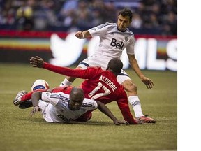 Vancouver Whitecaps defenders Steven Beitashour (top) and Pa-Modou Kah put the squeeze on Toronto FC's Jozy Altidore during this season's home opener last March at BC Place Stadium. The veteran duo had their contract options declined on Tuesday by the Caps.