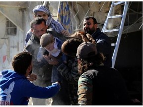 Syrian men rescue a toddler from the rubble of a building following a reported air strike by Syrian government forces on the Sukkari neighborhood of Syria’s northern city of Aleppo.