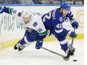 Tampa Bay Lightning center Jonathan Marchessault (42) moves the puck around Vancouver Canucks defenseman Alex Biega (55) during the second period of an NHL hockey game Tuesday, Dec. 22, 2015, in Tampa, Fla.
