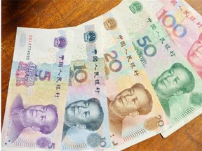 This photo illustration taken on March 17, 2014 shows Chinese yuan bank notes in China’s financial capital of Shanghai. China’s yuan traded weaker against the US dollar on March 17 after the central bank allowed the tightly-controlled currency to move in a wider range in a long-anticipated financial reform.