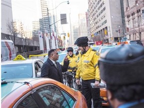 A Toronto taxi driver has some words for a Toronto police officer during an Uber protest organized by cab drivers in downtown Toronto last week.