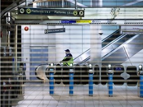 Transit security officers stand outside the Commercial-Broadway Skytrain station after the commuter train system was shut down following an earthquake late Tuesday.