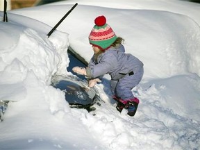 Tess Jorgensson, 3, helps her father dig their car out of snow in Alexandria, Va., Sunday, Jan. 24, 2016. Millions of Americans were digging themselves out after a mammoth blizzard with hurricane-force winds and record-setting snowfall brought much of the East Coast to an icy standstill. (AP Photo/Cliff Owen)