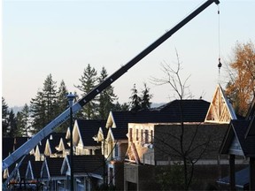 A truss is lowered into place at a new home construction site on Burke Mountain in Coquitlam.