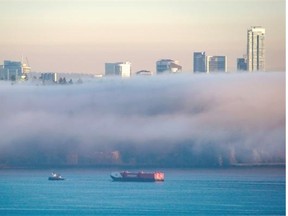 A tugboat pulls a Seaspan barge on Burrard Inlet as fog envelopes Stanley Park in Vancouver on Jan. 24, 2014. Seaspan Shipyards has donated $2 million to the University of British Columbia to support naval architecture and marine engineering programs.