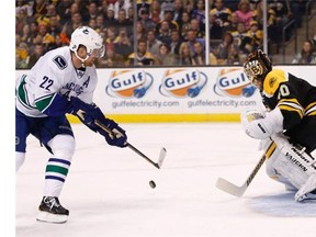 Tuukka Rask #40 of the Boston Bruins makes a save on a shot by Daniel Sedin #22 of the Vancouver Canucks.