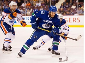 Vancouver Canucks #9 Brandon Prust and Edmonton Oilers #19 Justin Schultz battle for the puck  in tehefirst period of a pre season NHL hockey game at Rogers Arena, Vancouver October 03 2015.