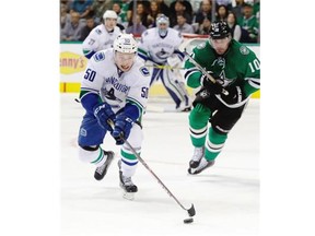 Vancouver Canucks center Brendan Gaunce (50) skates with the puck past Dallas Stars left wing Patrick Sharp (10) during the first period of an NHL hockey game Thursday, Oct. 29, 2015, in Dallas.