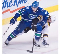 Vancouver Canucks center Bo Horvat (53) fights for control of the puck with Boston Bruins left wing Loui Eriksson (21) during third period NHL action Vancouver, B.C. Saturday, Dec. 5, 2015.