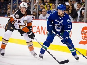 Vancouver Canucks #22 Daniel Sedin and Anaheim Ducks #42 Josh Manson look for the puck in the first period of a regular season NHL hockey game at Rogers Arena, Vancouver January 01 2016.
