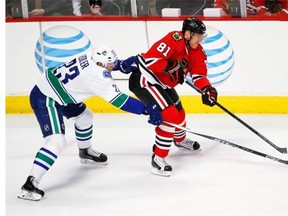 Vancouver Canucks defenceman Alexander Edler (23) reaches for the puck in front of Chicago Blackhawks right wing Marian Hossa (81).