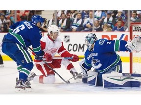 Vancouver Canucks defenceman Yannick Weber and Detroit Red Wings forward Justin Abdelkader look for the puck in front of Canucks goalie Ryan Miller in the second period of Detroit’s 3-2 overtime win at Rogers Arena on Saturday.