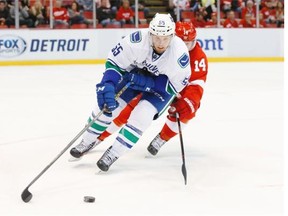 Vancouver Canucks defenseman Alex Biega (55) keeps the puck from Detroit Red Wings center Gustav Nyquist (14) in the first period of an NHL hockey game Friday, Dec. 18, 2015 in Detroit.