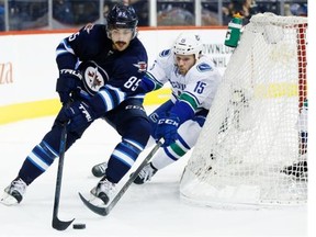 Vancouver Canucks’ Derek Dorsett (15) chases Winnipeg Jets’ Mathieu Perreault (85) around the back of his net during second period NHL action in Winnipeg on Wednesday, November 18, 2015.